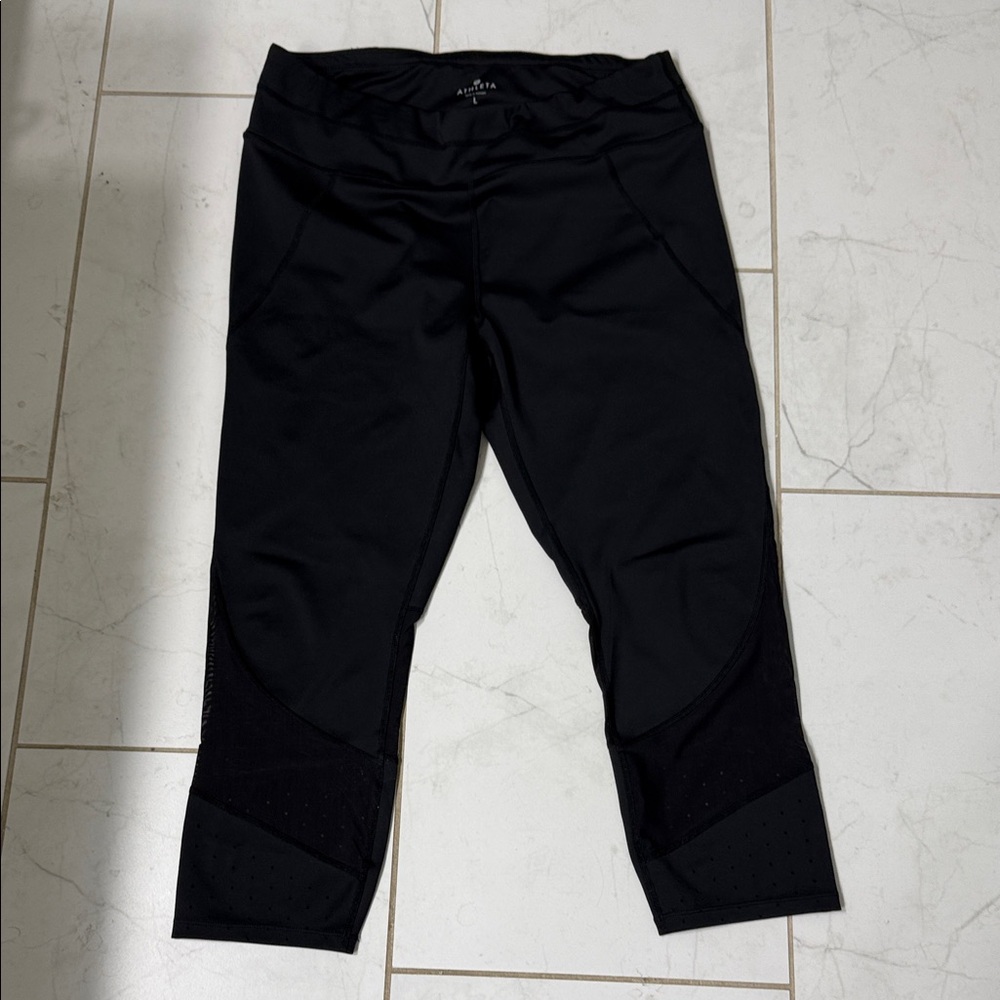 Athleta Black Capri Leggings with decorative netting at ankle.